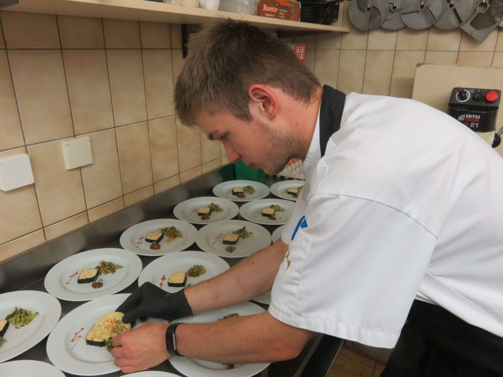 Juniorchef & Koch Martin Tiefnig beim Anrichten von Speisen